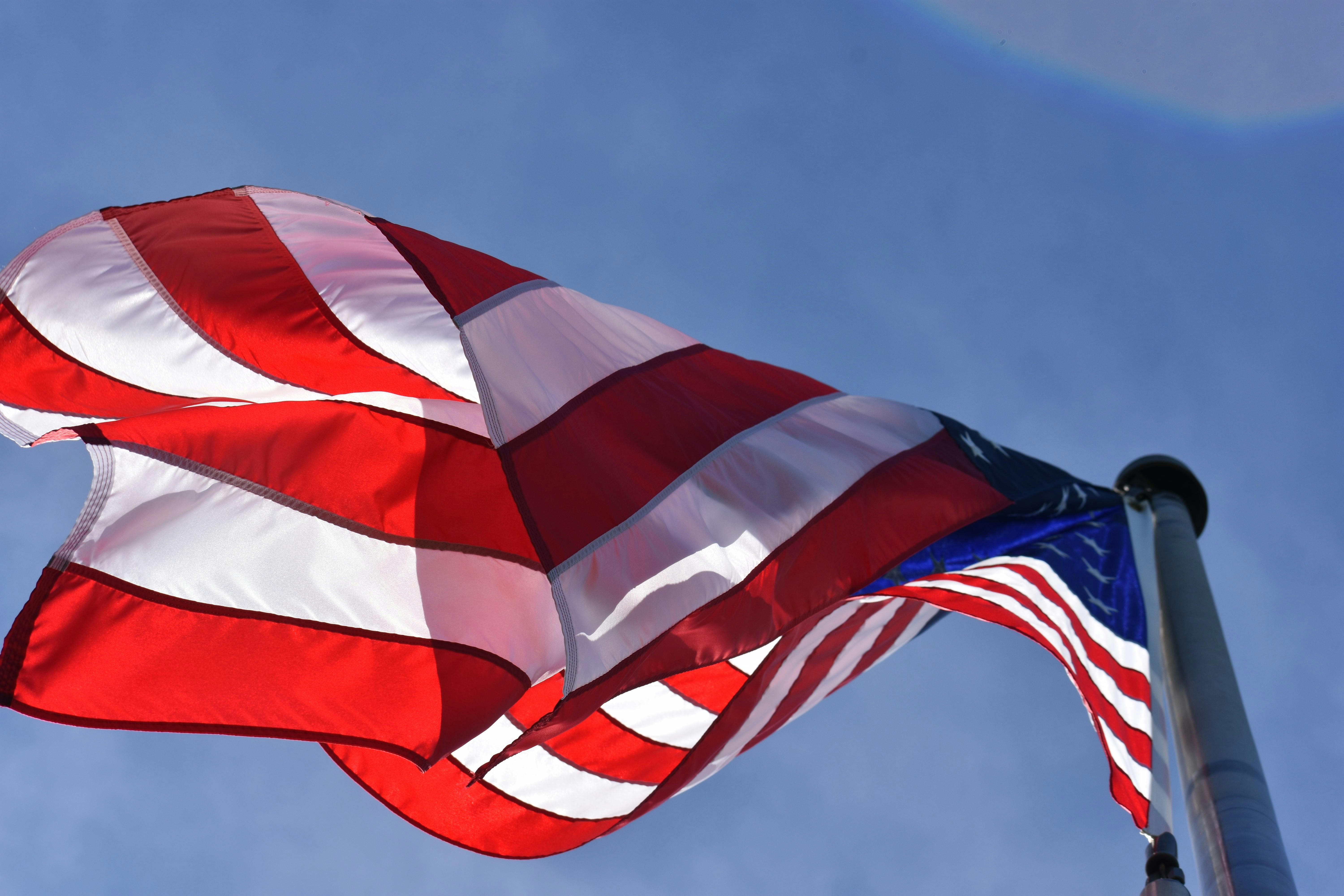 American flag waving under a blue sky